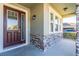 Close-up of a front porch with stone columns, a wood door, and windows, offering curb appeal at 2417 Annacella Ave, Kissimmee, FL 34741