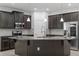 Gourmet kitchen featuring a large island, stainless steel appliances, dark cabinetry, and pendant lighting at 2417 Annacella Ave, Kissimmee, FL 34741