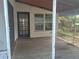 View of covered back porch with wooden flooring and dark door at 2603 E Lake Hartridge Dr, Winter Haven, FL 33881