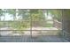 View from back porch with a screened-in deck, and wooden railing overlooking lush greenery at 2603 E Lake Hartridge Dr, Winter Haven, FL 33881