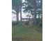 Lush backyard with a wooden dock, waterfront access, and mature trees at 2603 E Lake Hartridge Dr, Winter Haven, FL 33881