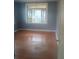 Bright bedroom with hardwood floors and a large window providing natural light at 2603 E Lake Hartridge Dr, Winter Haven, FL 33881
