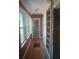 Hallway with wood floors, built-in shelves, and multiple windows for natural light at 2603 E Lake Hartridge Dr, Winter Haven, FL 33881