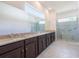 Bathroom vanity with dual sinks, granite countertop and glass enclosed shower at 2604 Meadowedge Loop, St Cloud, FL 34772