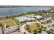 Aerial view showcasing a community pool, tennis courts, clubhouse, lake and surrounding landscaping at 2604 Meadowedge Loop, St Cloud, FL 34772