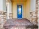 Inviting front porch featuring brick columns and steps, leading to a bright blue front door at 2604 Meadowedge Loop, St Cloud, FL 34772