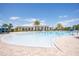 Resort-style zero-entry community pool with palm trees and a view of the community clubhouse at 2604 Meadowedge Loop, St Cloud, FL 34772