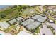 Aerial view featuring tennis courts and lush landscaping by a serene pond at 2604 Meadowedge Loop, St Cloud, FL 34772
