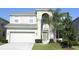 Charming two-story home with lush green lawn, attached two-car garage, and covered entryway at 2605 Daulby St, Kissimmee, FL 34747