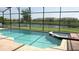 Inviting screened-in pool area with attached jacuzzi and serene water view at 2605 Daulby St, Kissimmee, FL 34747