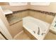 Inviting bathtub with granite countertops, tiled backsplash, and brushed nickel faucet at 2752 Bellewater Pl, Oviedo, FL 32765