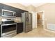 Modern kitchen with stainless steel appliances and granite countertops adjacent to laundry area at 2752 Bellewater Pl, Oviedo, FL 32765
