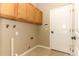 Functional laundry area with upper cabinets, tile flooring, and utility connections at 2752 Bellewater Pl, Oviedo, FL 32765
