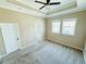 Large bedroom featuring a tray ceiling with fan, carpeted floors, and a doorway to the bathroom at 276 Celebration Blvd, Celebration, FL 34747