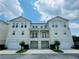 Beautiful townhouse with a two-car garage and balcony, set against a partly cloudy sky at 276 Celebration Blvd, Celebration, FL 34747