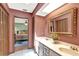 Bathroom with a double sink vanity and marble countertop next to bedroom with a doorway for convenient access at 28136 Tammi Dr, Tavares, FL 32778