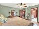 Serene bedroom featuring hardwood floors, a ceiling fan, and an ensuite bathroom at 28136 Tammi Dr, Tavares, FL 32778