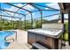 Relaxing hot tub with a screened enclosure, adjacent to a sparkling pool and lush greenery at 28136 Tammi Dr, Tavares, FL 32778