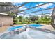 Inviting hot tub and pool under screened enclosure with backyard views, perfect for relaxing and enjoying the outdoors at 28136 Tammi Dr, Tavares, FL 32778