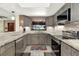 Well-lit kitchen showcasing granite countertops, stainless steel appliances, and gray cabinets at 28136 Tammi Dr, Tavares, FL 32778