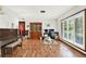Bright living room featuring hardwood floors, a piano, and a workspace near a window with shutter-style blinds at 28136 Tammi Dr, Tavares, FL 32778