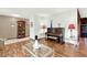 Cozy living room showcasing hardwood floors, a piano, and a decorative glass table at 28136 Tammi Dr, Tavares, FL 32778