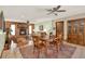 Open-concept living and dining areas featuring tile flooring, brick fireplace, ceiling fans, and plenty of natural light at 28136 Tammi Dr, Tavares, FL 32778