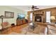 Living room features a brick fireplace, wood flooring, a ceiling fan and comfortable seating area at 28136 Tammi Dr, Tavares, FL 32778