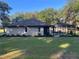 View of the rear of the home featuring a screened-in pool and well-maintained backyard at 3064 S Us Highway 41, Dunnellon, FL 34432