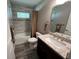 Well-lit bathroom featuring a shower-tub combo, granite countertop, and gray-toned wall and floor tiling at 3064 S Us Highway 41, Dunnellon, FL 34432