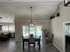 Dining area with views of the screened-in pool and modern lighting fixtures at 3064 S Us Highway 41, Dunnellon, FL 34432