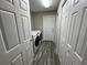 Bright laundry room with wooden floors, a washer and dryer, and access to multiple storage closets at 3064 S Us Highway 41, Dunnellon, FL 34432