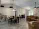 Open-concept living room with dining area, vaulted ceilings, and French doors leading to the outside at 3064 S Us Highway 41, Dunnellon, FL 34432