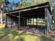 Exterior view of metal outbuilding with a pole barn roof and dirt floor on a treed lot at 3064 S Us Highway 41, Dunnellon, FL 34432