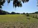 Expansive green pasture with mature oak trees visible in the distance offering serene rural views at 3064 S Us Highway 41, Dunnellon, FL 34432