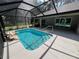 Gorgeous view of a screened-in backyard pool and patio with seating area in a well-landscaped area at 3064 S Us Highway 41, Dunnellon, FL 34432