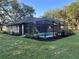 Backyard with a lovely screened-in pool, complemented by lush landscaping and a serene atmosphere at 3064 S Us Highway 41, Dunnellon, FL 34432