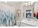 Charming bathroom with a forest-themed shower curtain, a white vanity, and bright lighting at 3294 Hanging Tide St, Winter Garden, FL 34787