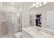 Bright bathroom featuring a glass-enclosed shower, white vanity, and a view into the walk-in closet at 3294 Hanging Tide St, Winter Garden, FL 34787