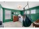 Inviting bedroom with green walls, a stylish hanging chair, and natural light streaming through the windows at 3294 Hanging Tide St, Winter Garden, FL 34787