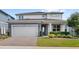 Beautiful two-story home with a brick driveway, lush landscaping, and a charming front porch at 3294 Hanging Tide St, Winter Garden, FL 34787