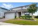 Charming two-story home with a brick driveway, manicured lawn, and stone accents at 3294 Hanging Tide St, Winter Garden, FL 34787