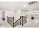 Upstairs hallway with wood and wrought iron banister, neutral carpet and natural light at 3294 Hanging Tide St, Winter Garden, FL 34787