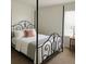 Bedroom featuring an iron frame four-poster bed, neutral walls, and bright natural light from a window at 358 Fairfield Dr, Sanford, FL 32771