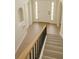 Carpeted staircase with black railings and light wood floors leading to the entryway at 358 Fairfield Dr, Sanford, FL 32771