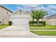 Charming home showcasing a two-car garage, well-manicured lawn, and decorative landscaping adding curb appeal at 3945 Angola Ln, Sanford, FL 32771