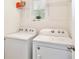Bright laundry room featuring white washer and dryer with shelving and natural light at 3945 Angola Ln, Sanford, FL 32771