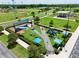 Aerial view of a playground featuring a variety of play equipment, shaded seating, and landscaped surroundings in a community area at 3945 Angola Ln, Sanford, FL 32771