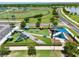 Aerial view of a colorful playground featuring slides, swings, and shaded seating areas near baseball fields and a parking lot at 3945 Angola Ln, Sanford, FL 32771