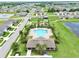 Aerial view of a community pool with a recreation center surrounded by green space, palm trees, and neighborhood homes at 3945 Angola Ln, Sanford, FL 32771